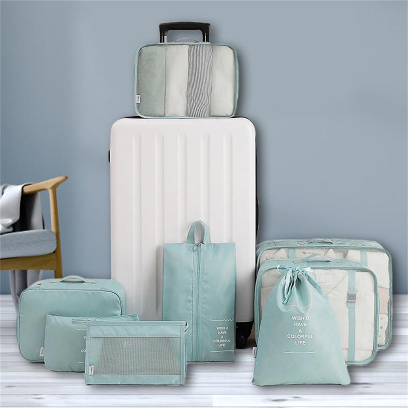 Mint travel organizer bags arranged around a suitcase